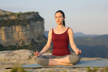 Fototapeta na wymiar Mixed race woman doing yoga exercise in the mountain
