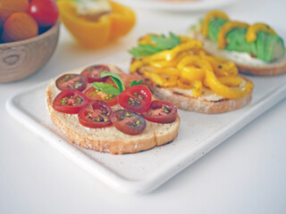 Vegan bruschetta. Delicious bruschetta with tomatoes, yellow peppers and avocado on a white plate. Appetizing Vegetable Snack Cheese Sandwiches