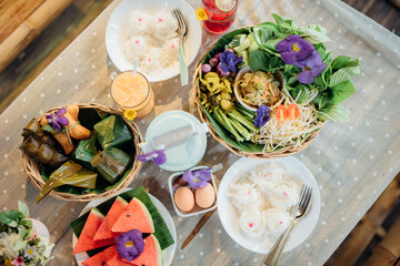 A set of traditional Thai food, dessert, drink, and fresh seasonal fruits.