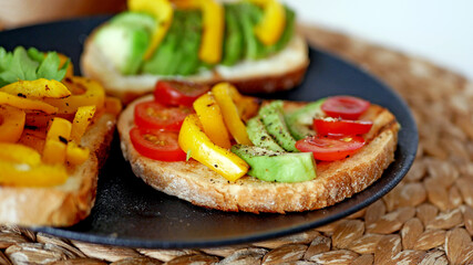 Vegan bruschetta. Delicious bruschetta with tomatoes, yellow peppers and avocado on a white plate. Appetizing Vegetable Snack Cheese Sandwiches