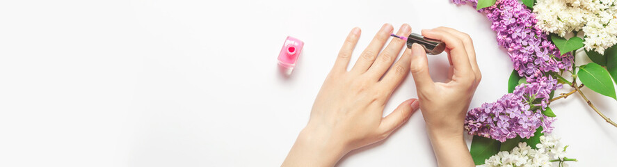 Fototapeta premium woman paints her nails with varnish, close-up. Beauty concept. Banner