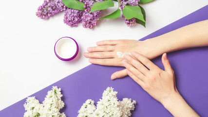Home moisturizing, dermatology, cosmetic and anti-aging care. female hands apply cream on a white background. copy space