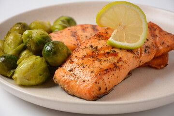 Fried salmon steaks. Cooked salmon steak with pepper, herbs, lemon, garlic, olive oil and Brussels sprouts. Grilled fresh fish.