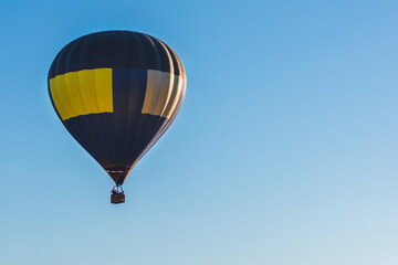 Fototapeta premium Hot Air Balloon on a blue sky.One Blue yellow hot air balloon in blue clear sky.Copy space.