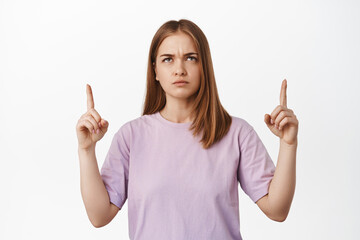 I disagree. Frowning girl looks upset, pointing and looking up with furrow eyebrows, judging smth...