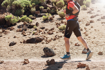 Male athlete run mountain race wth hydratation trail vest for running