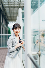 Fototapeta premium 外で待ち合わせをする若いビジネスウーマン