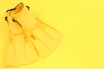 Pair of flippers on yellow background, flat lay. Space for text © New Africa