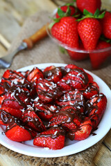 Strawberries with chocolate on a plate. Fresh strawberries in a bowl. Healthy summer dessert with strawberries.