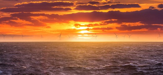 Renewable green electricity wind power generation offshore. Sunrise at decarbonization industry windmills business for regenerative energies. Clean energy renewables preventing climate change - 440737086