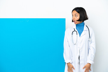 Young mixed race doctor woman with a big placard isolated on white background doing surprise gesture while looking to the side