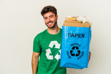 Young caucasian man man recycling cardboard isolated on white background happy, smiling and cheerful.