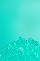 Fototapeta premium Beauty cosmetic clear gel sanitizer with bubbles texture on color green background. Flat lay mockup, copy space.