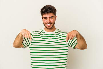 Young caucasian man isolated on white background points down with fingers, positive feeling.