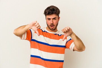 Young caucasian man isolated on white background showing thumb down and expressing dislike.