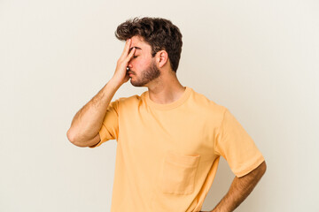 Young caucasian man isolated on white background having a head ache, touching front of the face.