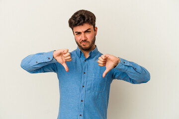 Young caucasian man isolated on white background showing thumb down, disappointment concept.