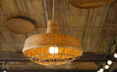 Wooden pendant lamp tropical and vintage style installed on bamboo ceiling.