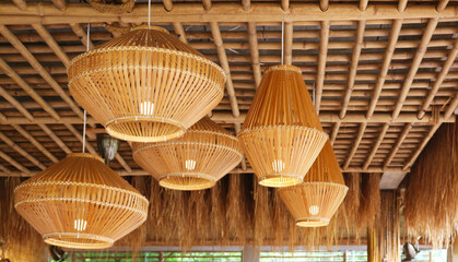 Wooden pendant lamp tropical style installed on bamboo ceiling.