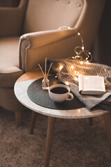 Cozy home atmosphere: accent chair and marble coffee table with black tea cup, liquid aroma...