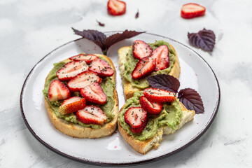 Toast with mashed avocado, strawberries and chia seeds, Delicious breakfast or snack, Clean eating, dieting, vegan food concept. top view