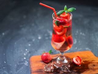 Strawberry refreshing ice tonic cocktail in a glass with a red straw
