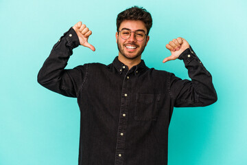 Fototapeta premium Young caucasian man isolated on blue background feels proud and self confident, example to follow.