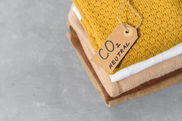 Clothes in stack with carbon emission paper recycled label