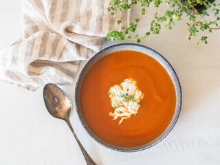 Blue bowl tomato creamy soup with stracciatella cheese and fresh thyme