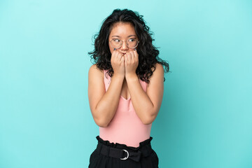 Young asian woman isolated on blue background nervous and scared putting hands to mouth
