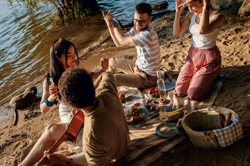 Diverse group of friends enjoying picnic by the river.