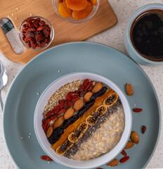 Breakfast in the kitchen, oatmeal with dried fruits and seeds and coffee. Healthy food concept