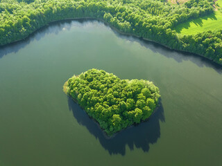View from the drone to the island formed in the form of a green heart surrounded by water, a lake....