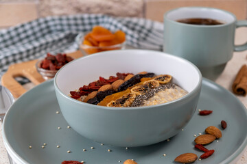 Breakfast in the kitchen, oatmeal with dried fruits and seeds and coffee. Healthy food concept
