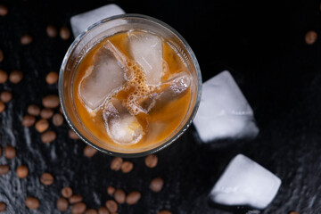 cold ice latte or coffee with milk on a dark black background