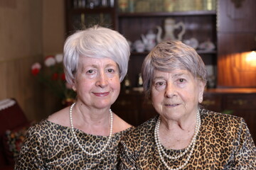 Senior sisters with matching leopard outfits 