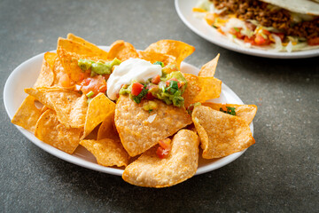 nachos tortilla chips with jalapeno, guacamole, tomatoes salsa and dip