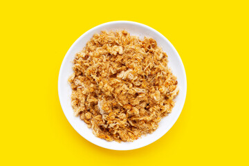 Dried shredded pork in white plate on yellow background.