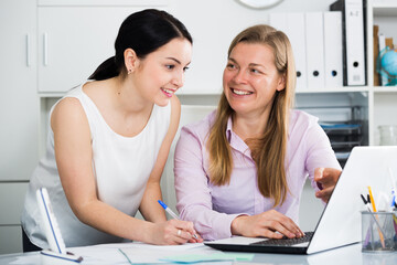 Obraz premium Two female employees having a productive day at work in office