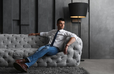 Handsome businessman on sofa indoors. Luxury lifestyle
