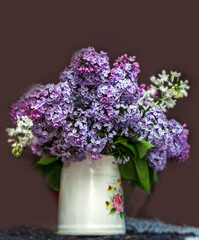 Lush bouquet of lilac in white mug