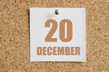december 20. 20th day of the month, calendar date.White calendar sheet attached to brown cork...