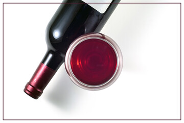 A glass and a bottle of red wine on a white background. View from above.