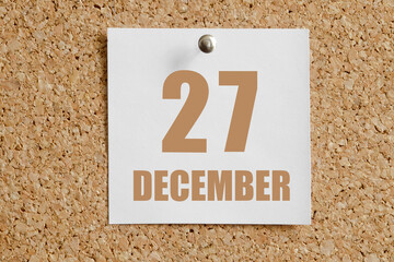 december 27. 27th day of the month, calendar date.White calendar sheet attached to brown cork board.Winter month, day of the year concept