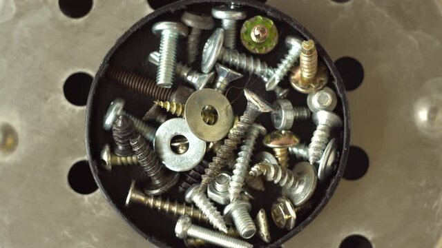 Self-tapping screws and screws. A group of parts. Construction fasteners. Metal screws. View from above. Rotation of objects. Close-up