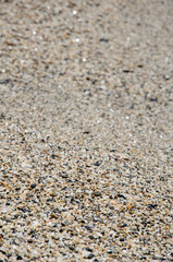 Fototapeta na wymiar Natural background concept. Surface of the rocky beach. Pebble texture. Sea stones of various sizes cover the seaside. Selective focus multi-colored pebbles on the seashore.