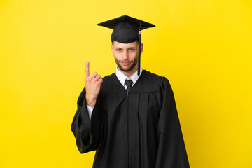 Young university graduate caucasian man isolated on yellow background pointing with the index finger a great idea