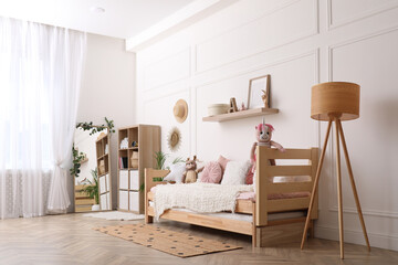 Cute child's room interior with comfortable bed and toys