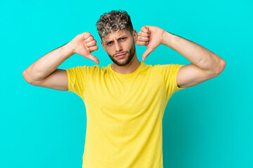 Fototapeta na wymiar Young handsome caucasian man isolated on blue background proud and self-satisfied