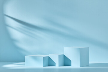 Blue background for product presentation with shadows and light. Empty podiums. Mockup.
